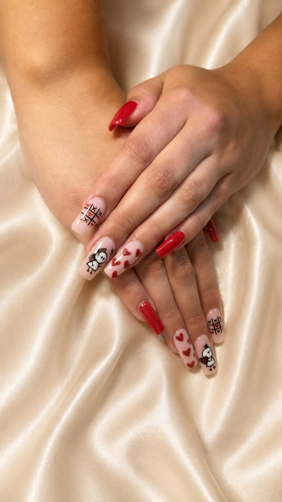 Manicura roja con diseños románticos sobre tela satinada